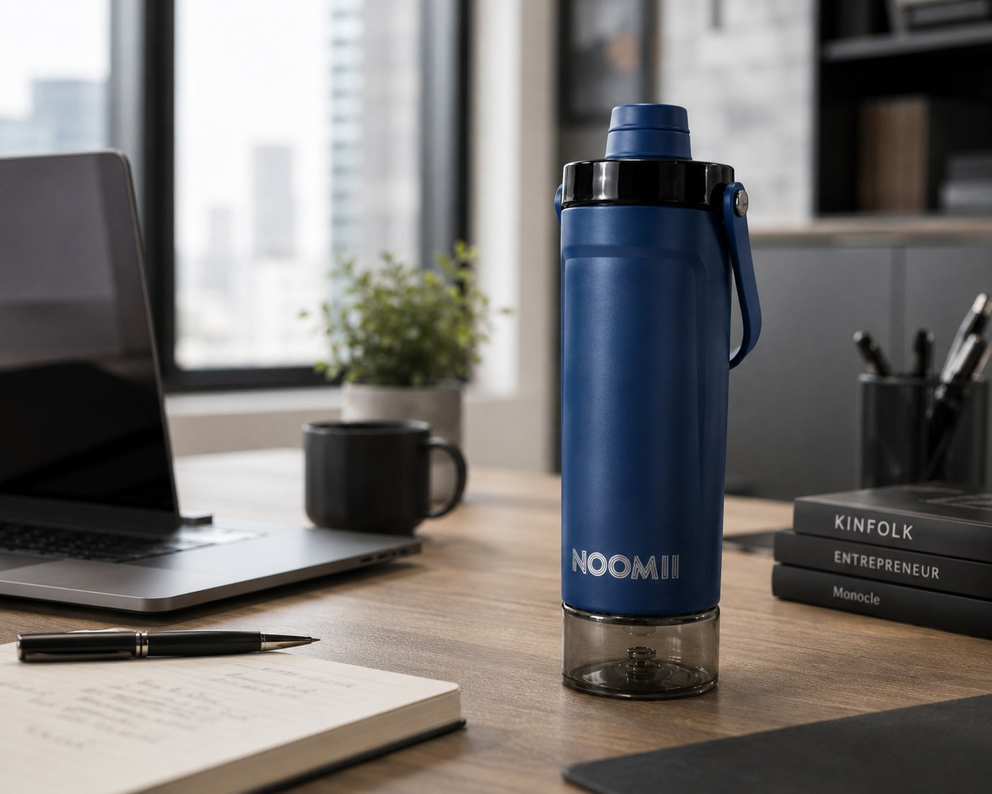NooMii ProShake 600 in Dunkelblau auf einem Schreibtisch im Büro neben Laptop und Notizbuch