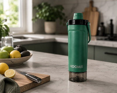 NooMii ProShake 600 in Grün auf einer Küchentheke mit Zitronen und Schneidebrett