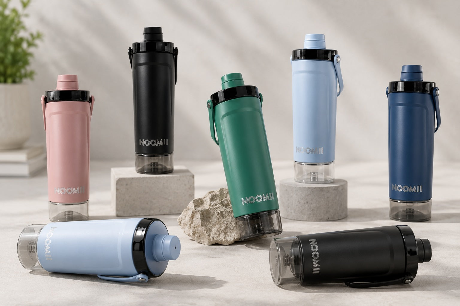 NooMii ProShake 600 Edelstahl-Protein-Shaker in allen sechs Farben auf Steinpodesten arrangiert